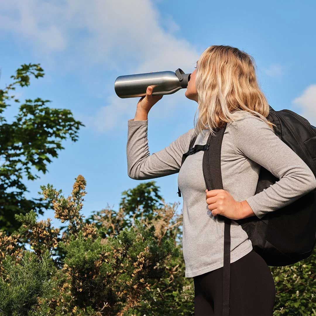 Girl drinking from a Circular and Co bottle whilst hiking.