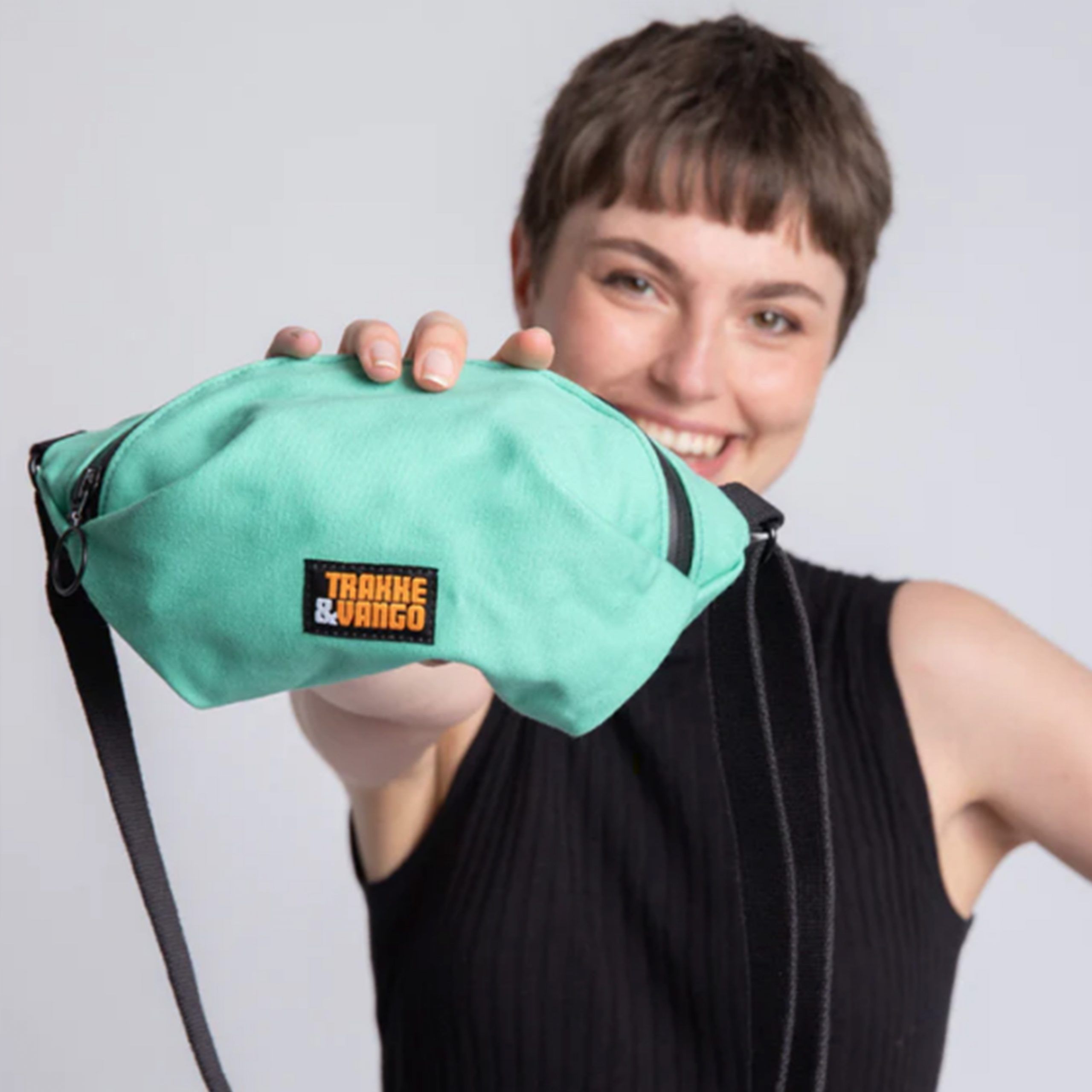 A woman holds up a Trakke Zero Waste Sling