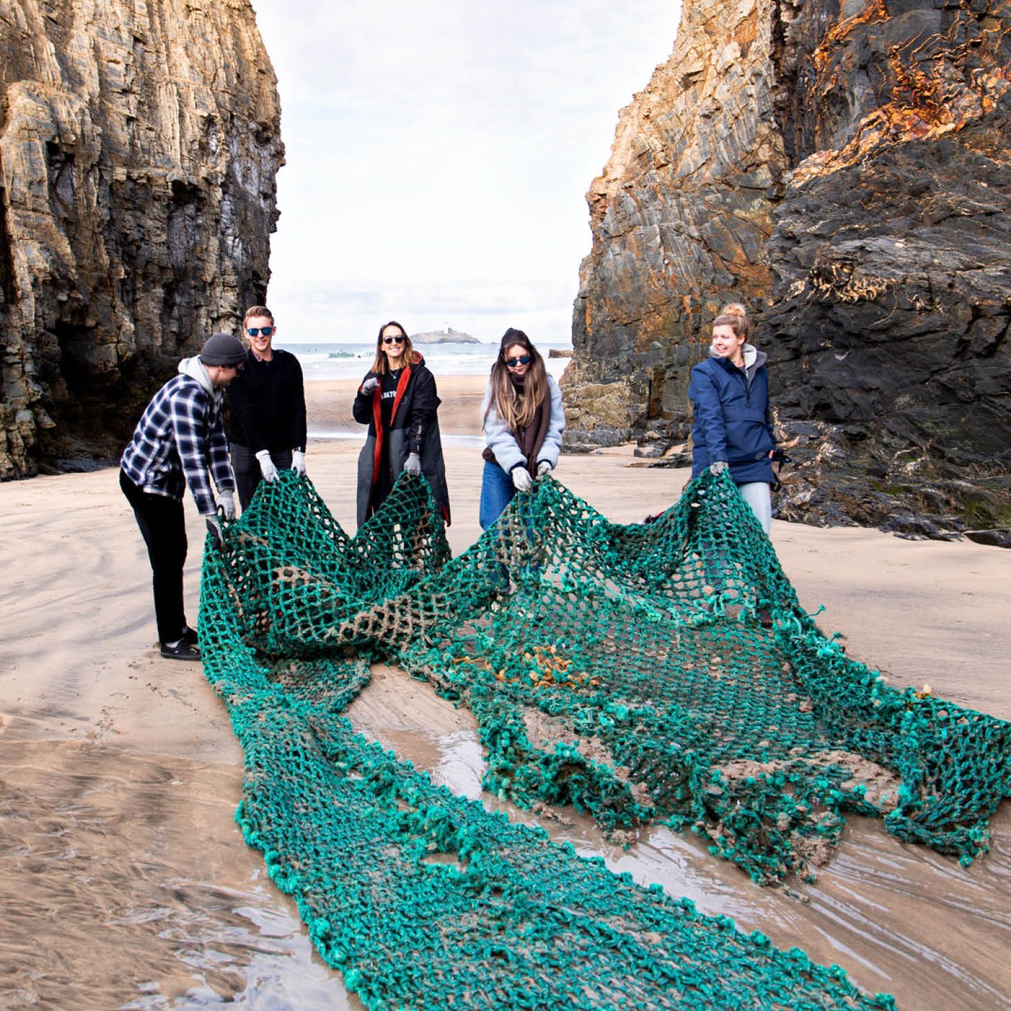 people dragging netting off a beach