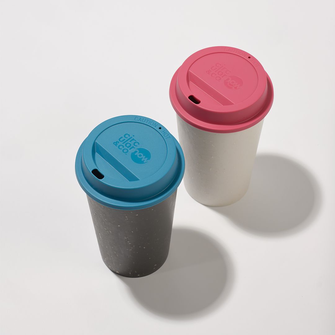 white reusable cup with pink lid and black reusable cup with blue lid