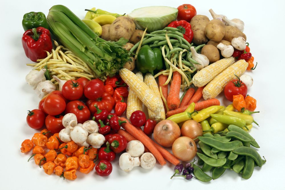 An assortment of fruit and veg on white surface.
