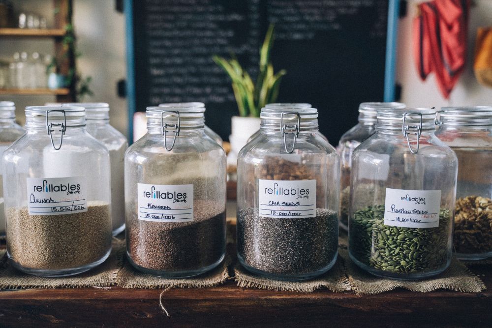 Glass jars filled with seeds on table in a refill shop.