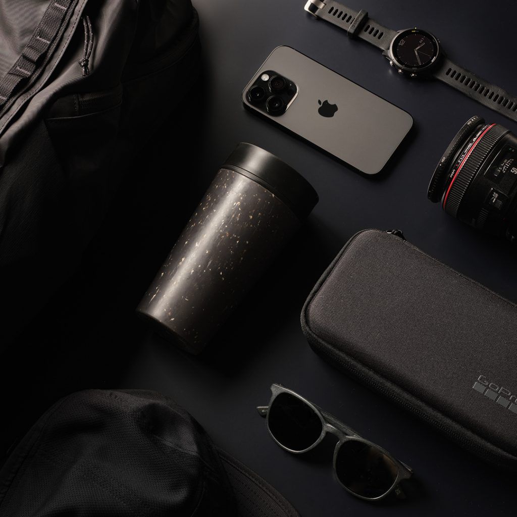 black reusable cup on black table with other black items