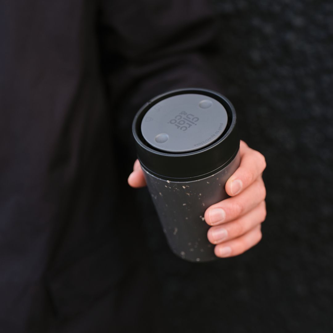 hand holding a black reusable cup