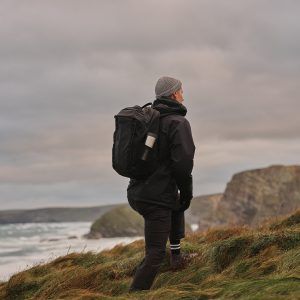 man hiking with steel reusable cup in side pocket of backpack