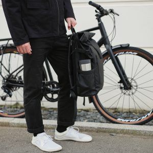 man holding backpack with steel reusable cup in side pocket