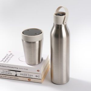 8oz Stainless Steel Reusable Travel Mug with pebble white lid and 500ml stainless steel Reusable Water Bottle with pebble white lid Bundle on a set of books