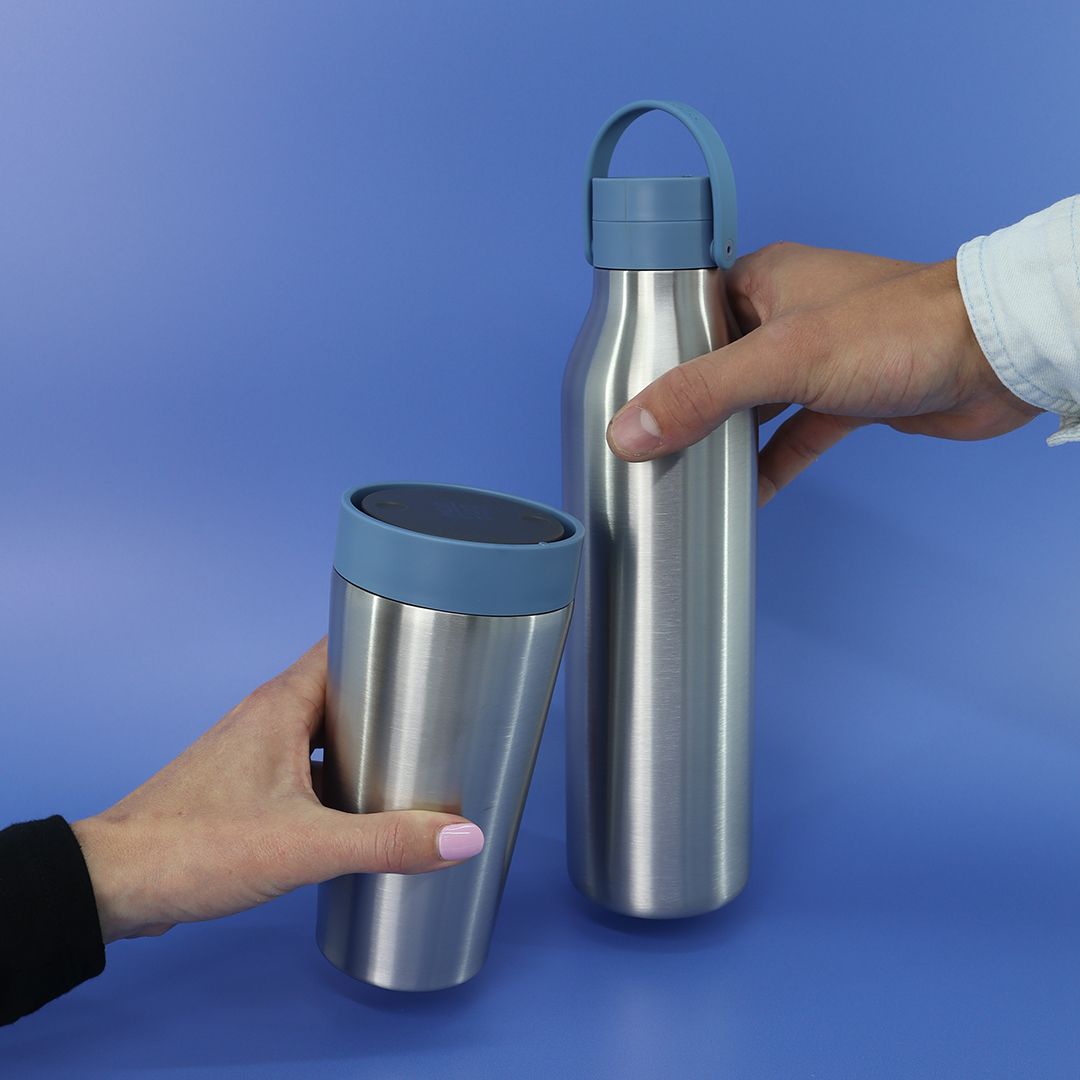 12oz Stainless Steel reusable Travel Mug with rockpool blue lid and 750ml Stainless Steel Reusable Water Bottle with rockpool blue lid Bundle being held